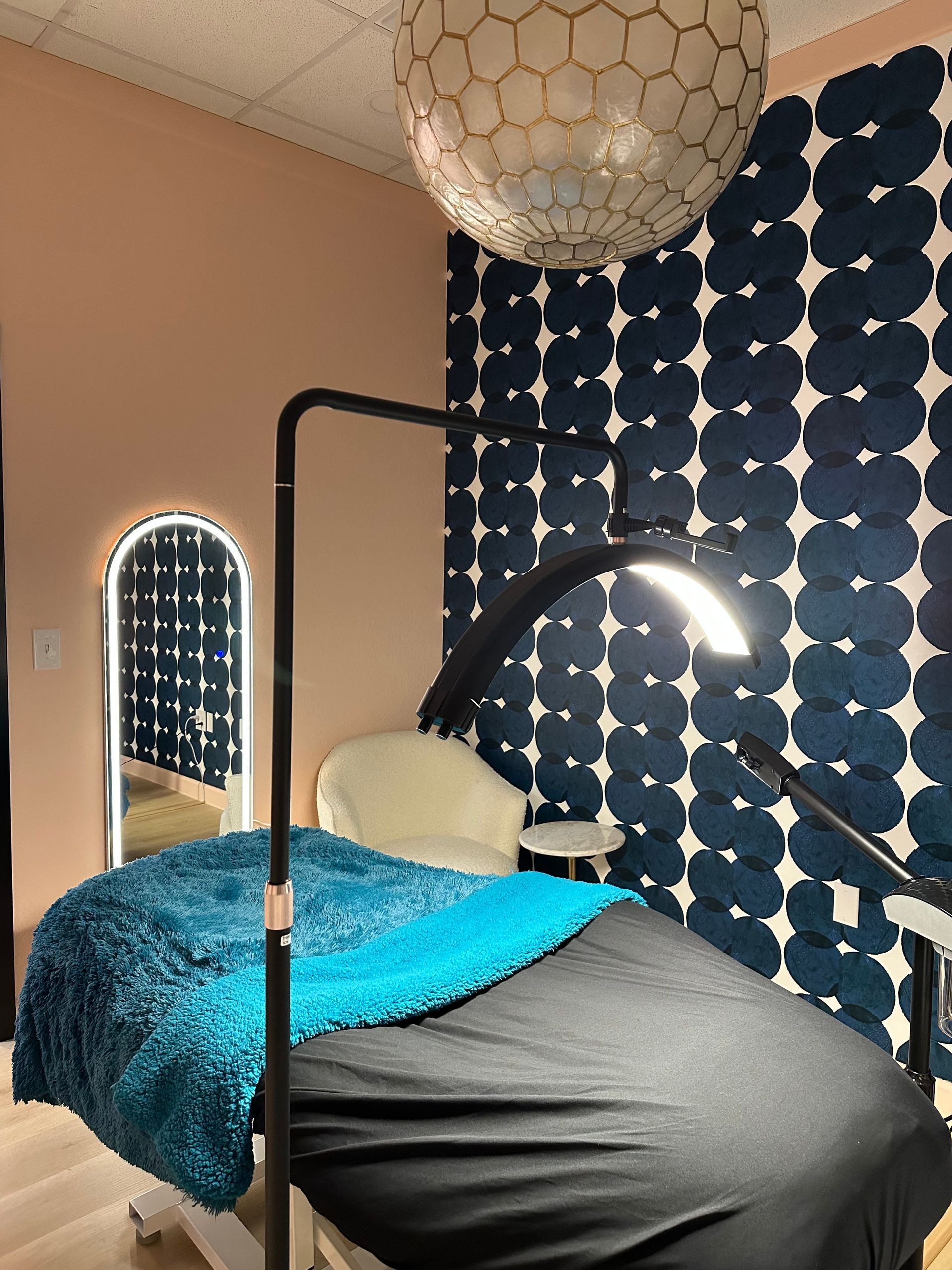 A room with a bed and a mirror and a lamp