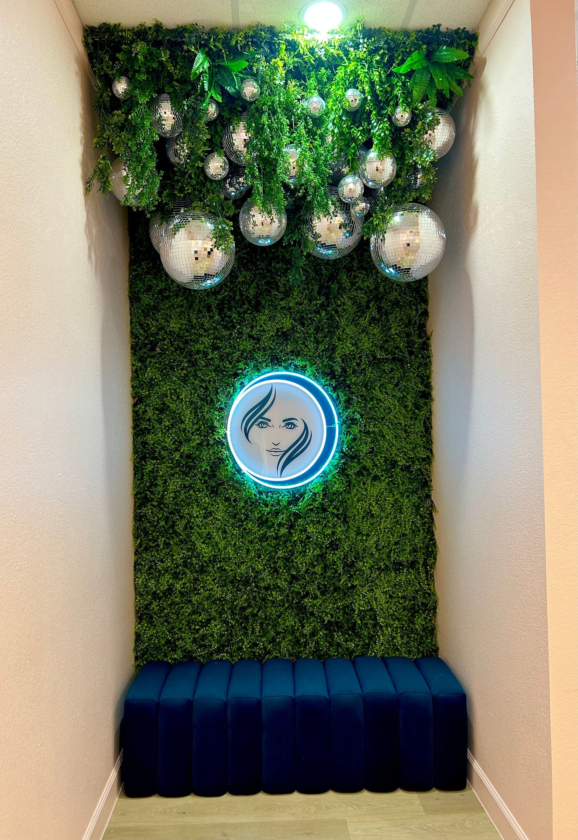 A hallway with a green wall and a blue bench.